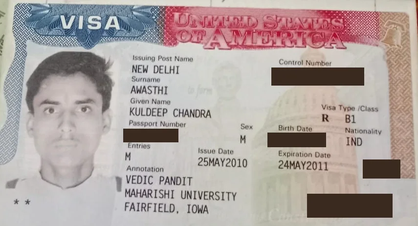 US visa of Acharya Kuldeep Awasthi, type B-1, with the printed annotation “VEDIC PANDIT / MAHARISHI UNIVERSITY / FAIRFIELD, IOWA”. Personal numbers are blacked out.
